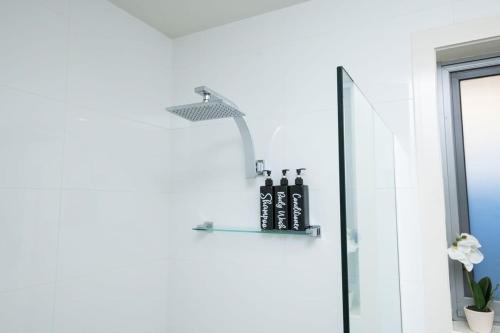 ein Badezimmer mit einem Regal mit Flaschen darauf in der Unterkunft The Endsleigh -1 Bedroom Villa, Free Wifi, Near CBD in Orange