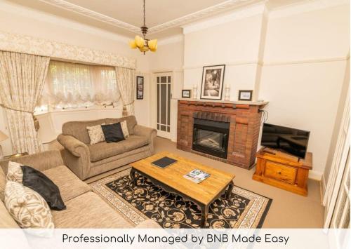 a living room with a couch and a fireplace at Hillside Cottage │ Comfy, Spacious, Walk to CBD & Stannies in Bathurst