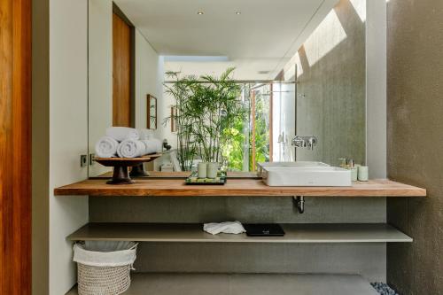 a bathroom with a sink and a mirror at Domisili Villas Canggu Bali by Fays Hospitality in Canggu