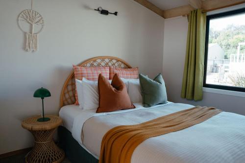 1 dormitorio con cama con almohadas y ventana en The PC Cottage, en Port Campbell