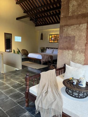 a room with two beds and a couch with a table at Pao Homes - Riverside House in Hoi An