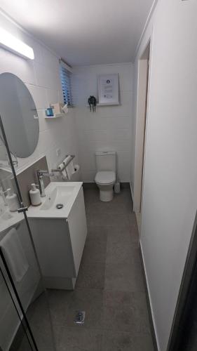 a bathroom with a toilet and a sink and a mirror at Moffat Beach Motel Caloundra in Caloundra