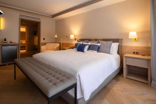 a large white bed with a bench in a room at Camino Real Polanco Mexico in Mexico City