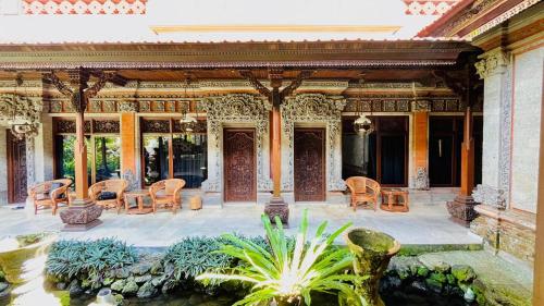 a building with a patio with chairs and a pond at Puri Karang Residence in Bangli