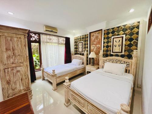 1 dormitorio con 2 camas y ventana en Puri Karang Residence, en Bangli