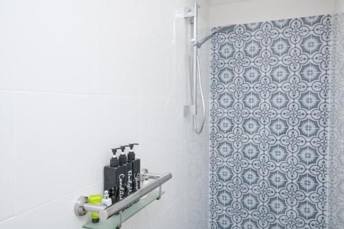 uma casa de banho com um chuveiro com uma cortina de chuveiro com padrões azuis em Blue Door Apartment 2 - Spacious CBD Apartment em Orange