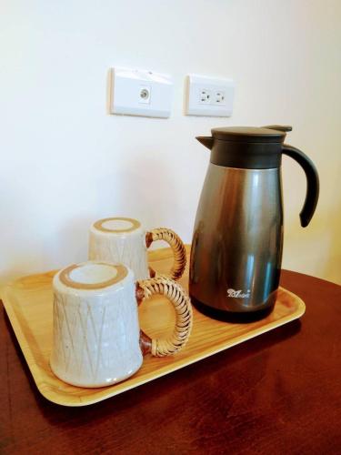 a coffee pot and two rolls of paper on a tray at Uncle Tien's Farm in Sha-lao-ts'un