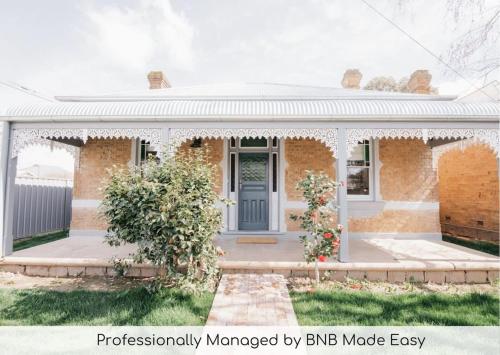 a brick house with a blue door at Dimby Cottage Beautifully Restored Heritage Home in Orange