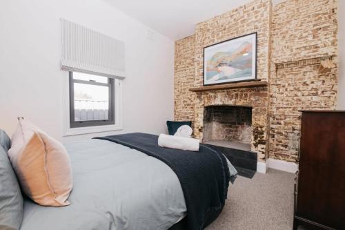 um quarto com uma cama e uma lareira em Dimby Cottage Beautifully Restored Heritage Home em Orange