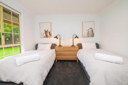 2 camas en una habitación con paredes blancas en Darcy Brown House Modern Country Escape, en Orange