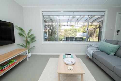 a living room with a couch and a table at Sweet Caroline Sunny & Spacious Sleeps 6 in Orange