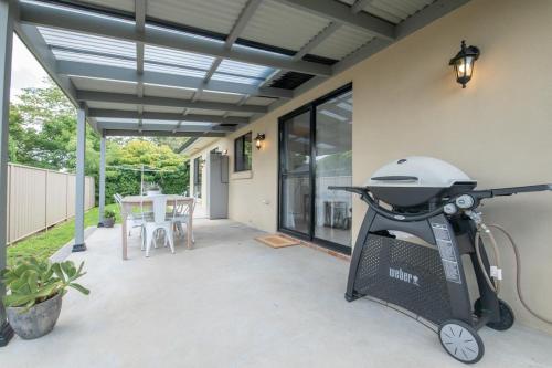 a backyard patio with a grill and a table at Villa 88 - Stylish, Modern, Fresh & Light in Orange