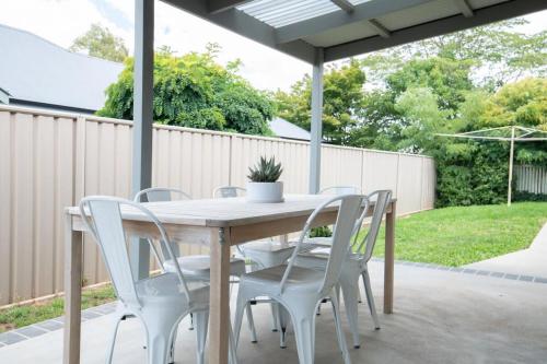 a wooden table and chairs on a patio at Villa 88 - Stylish, Modern, Fresh & Light in Orange