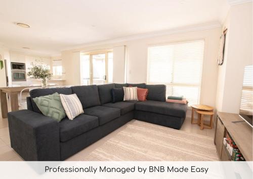 a living room with a couch and a kitchen at Park Villa - Near CBD, Spacious, Ideal for Work in Orange