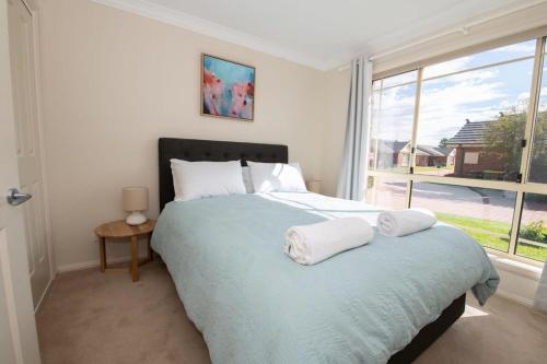 a bedroom with a large bed with two towels on it at Park Villa - Near CBD, Spacious, Ideal for Work in Orange