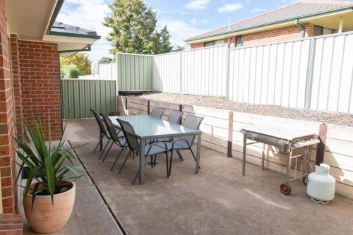 a patio with a table and chairs and a fence at Park Villa - Near CBD, Spacious, Ideal for Work in Orange