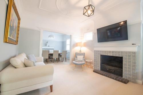 a living room with a couch and a fireplace at The Oaks on March Stunning & Elegant CBD Home in Orange