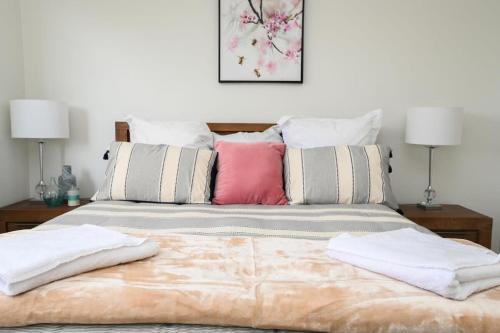 a bed with two pillows on top of it at Nile Cottage Cosy & Convenient, Close to CBD in Orange