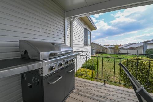 a grill on a patio with a balcony at Nile Cottage Cosy & Convenient, Close to CBD in Orange