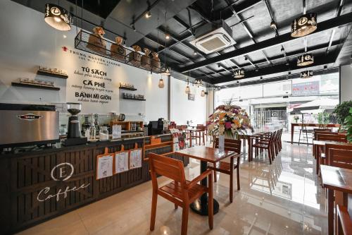 a restaurant with wooden tables and chairs and a counter at Paradise Cu Chi Hotel in Củ Chi
