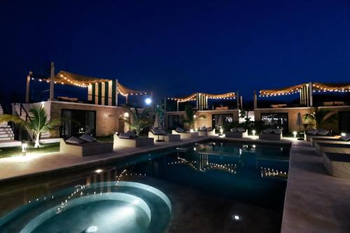 a swimming pool in front of a building at night at Bora Boutique - Adults Only in Puerto Escondido