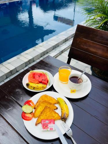 a table with two plates of food and a cup of coffee at Vang Vieng Global Hostel in Vang Vieng
