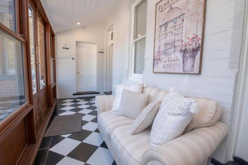a living room with a white couch and a checkered floor at LANSDOWNE House in Orange