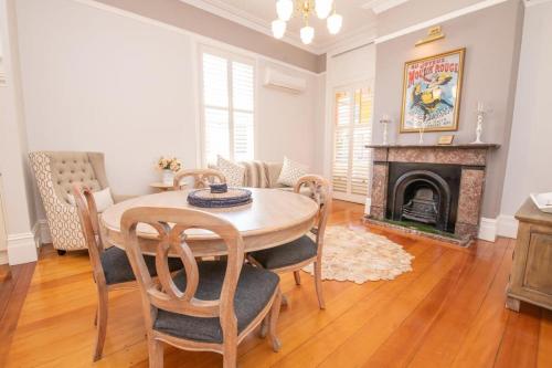 a dining room with a table and a fireplace at LANSDOWNE House in Orange