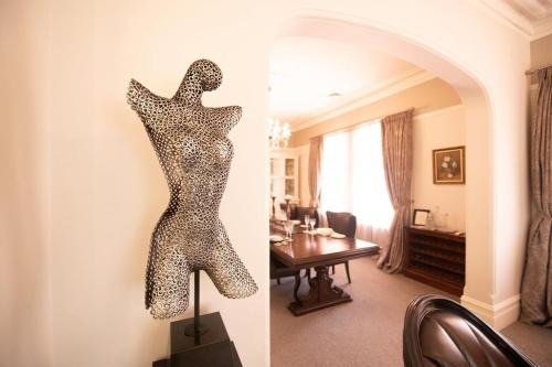 a metal sculpture of a woman on a wall in a room at LANSDOWNE House in Orange