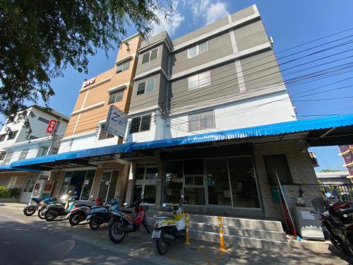 una fila di motociclette parcheggiate di fronte a un edificio di Ze Residence Ram Intra a Bangkok