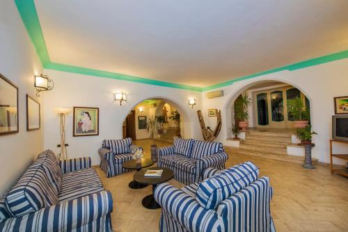 a living room with blue and white striped couches at Hotel Ossidiana Stromboli Center in Stromboli
