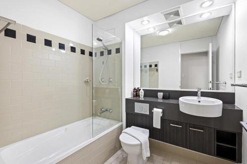 a bathroom with a toilet and a sink and a shower at Cosy Apartment in the Heart of Perth CBD in Perth