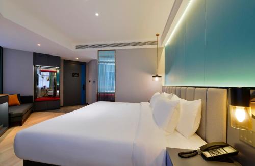 a large white bed in a room with a telephone at R Royalss Hotel, Yulin Yuxing Square in Yulin