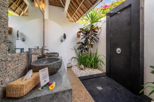 a bathroom with a sink and a bath tub at Villa Moana Poe Uluwatu in Uluwatu