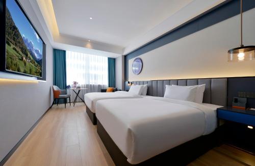 a hotel room with two beds and a table at R Royalss Hotel, Yulin Yuxing Square in Yulin