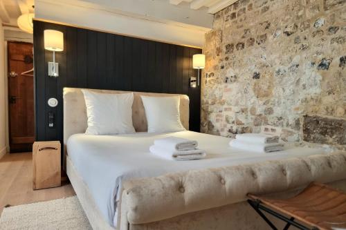 une chambre avec un grand lit avec des serviettes dessus dans l'établissement La Parenthèse Saint Jean - studio city center, à Honfleur