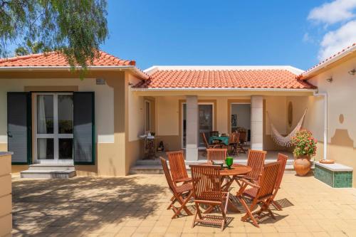 eine Terrasse mit Stühlen und einem Tisch vor einem Haus in der Unterkunft Casa de Férias by An Island Apart in Porto Santo