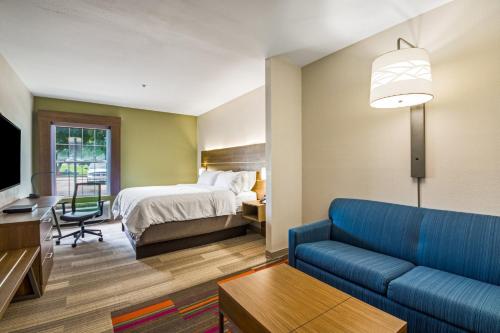 Habitación de hotel con cama y sofá en Holiday Inn Express Hotel & Suites Columbus, an IHG Hotel, en Columbus