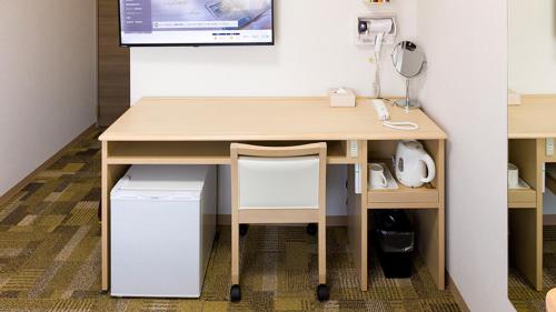a desk in an office with a phone on a wall at Toyoko Inn Nagasaki Ekimae in Nagasaki