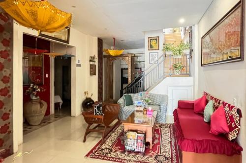a living room with a red couch and a table at Urbanview Poma Hotel in Lheue