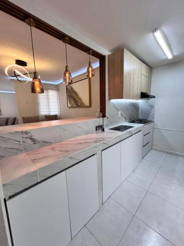 a kitchen with white cabinets and a counter top at Hermoso Departamento in Guadalajara