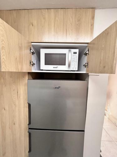 a kitchen with a microwave and a refrigerator at Hermoso Departamento in Guadalajara