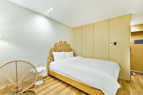 a bedroom with a large bed and a fan at Gyeongju Hotel Gonggan in Gyeongju