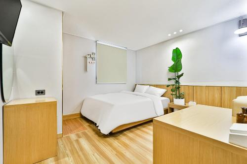 a bedroom with a white bed and a kitchen at Gyeongju Hotel Gonggan in Gyeongju