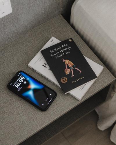 two books sitting on a table next to a cell phone at Magazine Vista Hotel Managed by The Ascott Limited in George Town