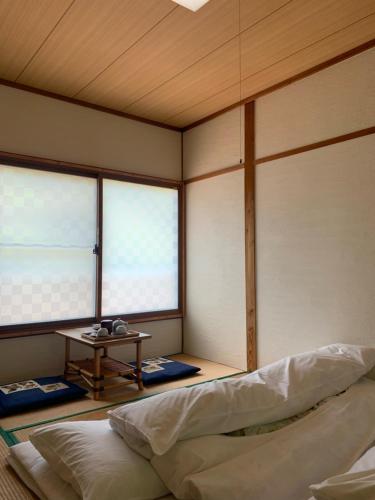 a corner of a room with a bed and a table at Iya Kankou Ryokan in Miyoshi