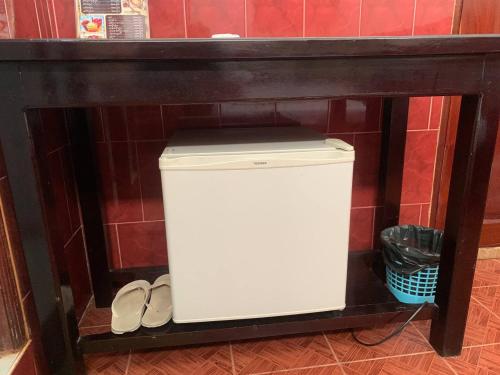 a white trash can in a shelf in a bathroom at Ditar Guest House D in Battambang