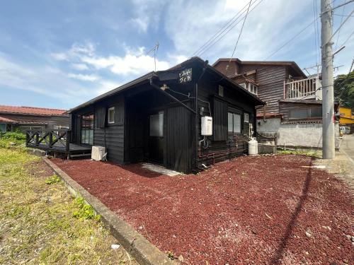 大島にあるとみやヴィラ 1組限定の前に土の山がある黒い家