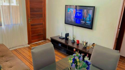 a living room with a television and a table with chairs at House Temporada in Búzios