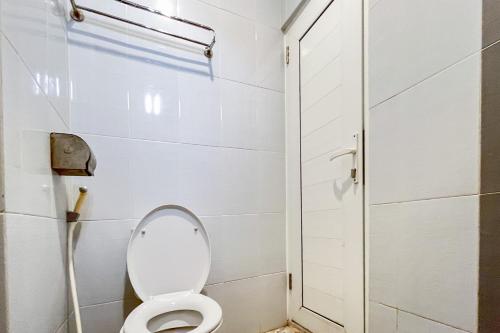 a white bathroom with a toilet and a shower at Urbanview Poma Hotel in Lheue